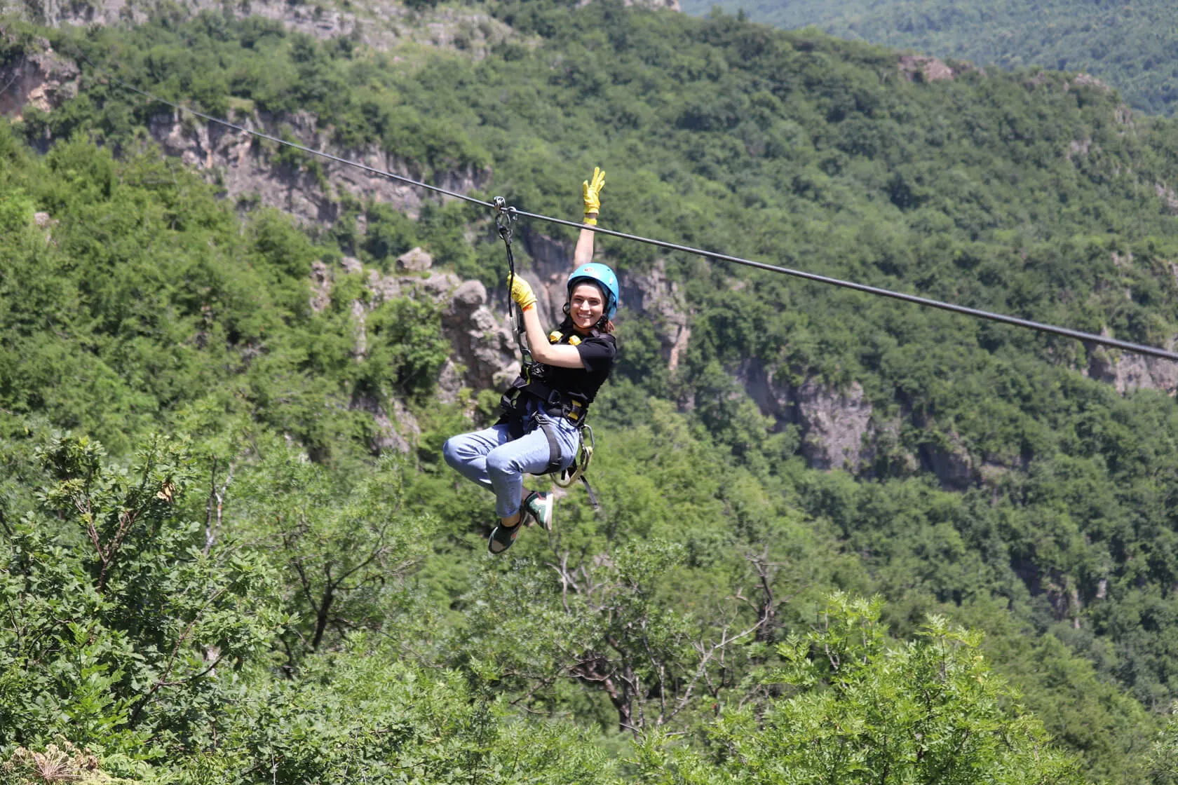 Guest waving from the zipline above the gorge