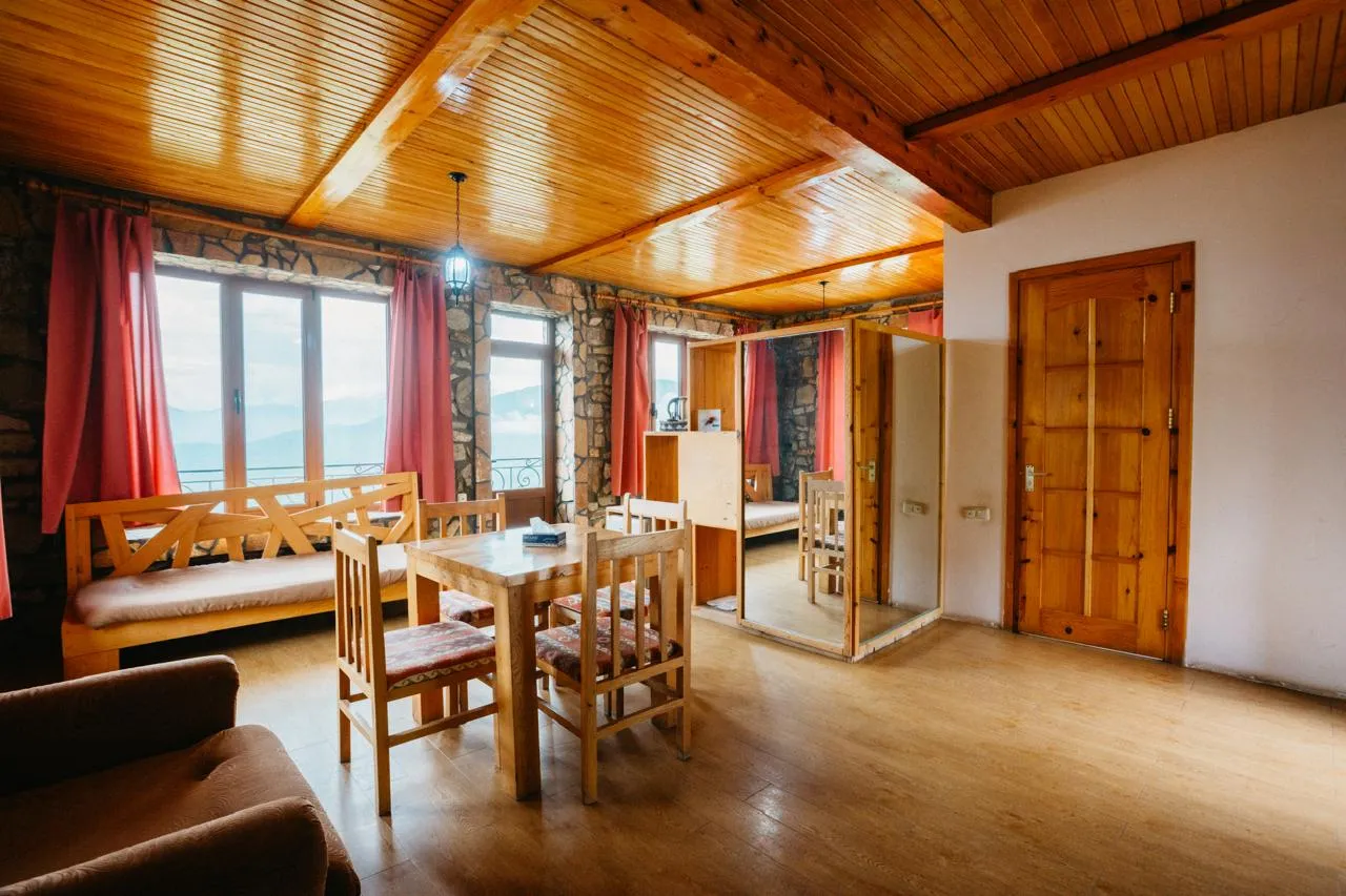 Wood-panelled cottage dining room with mountain views