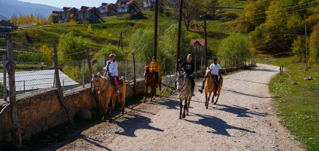 Riders on horseback on a village road above Yenokavan